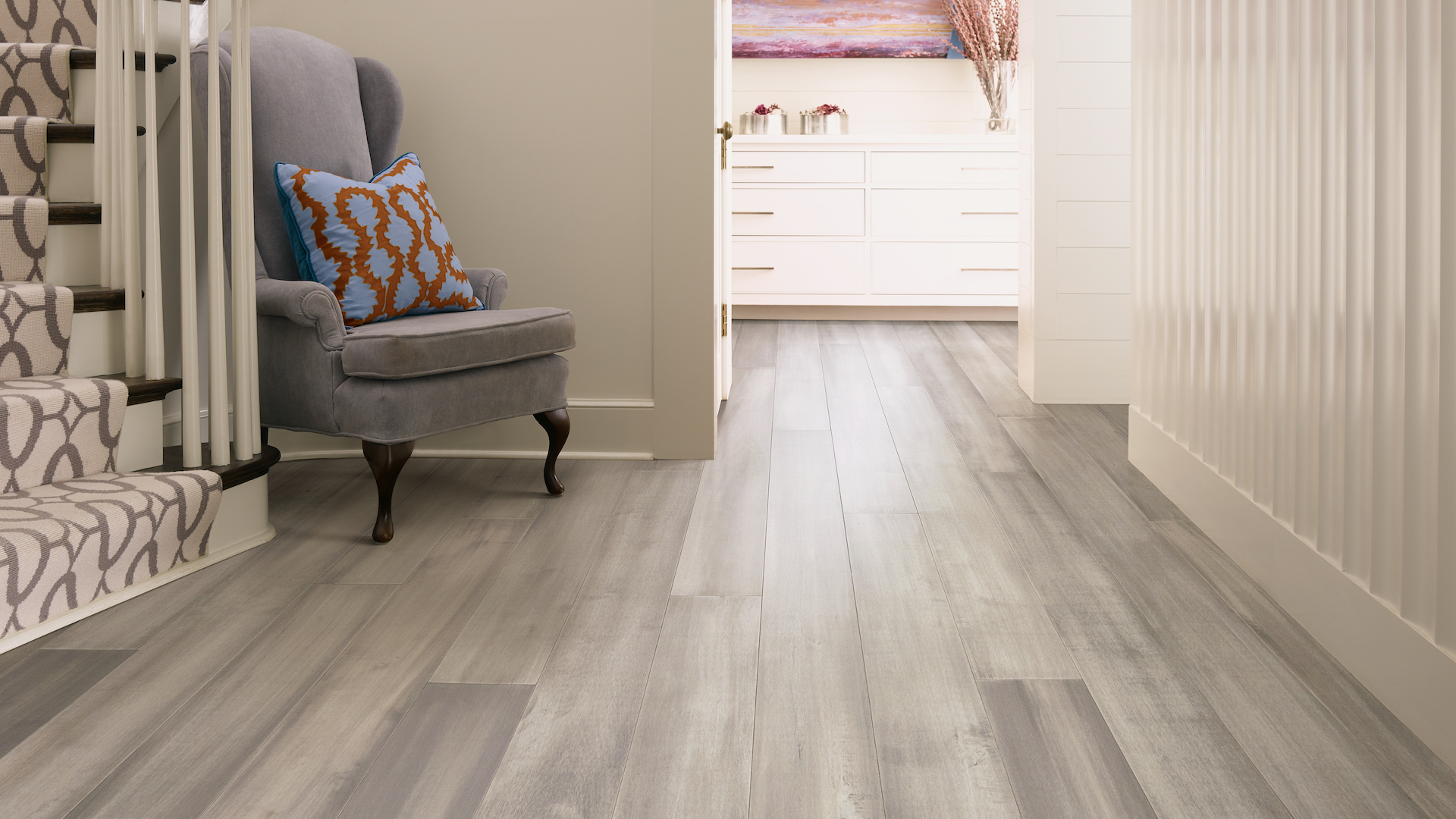 hardwood flooring in a hallway with staircase and decorative chair